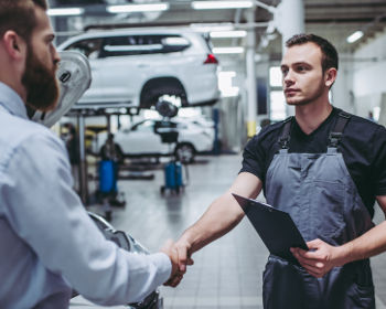 Carrossier professionnel offrant un service de qualité à un client pour la réparation de sa voiture